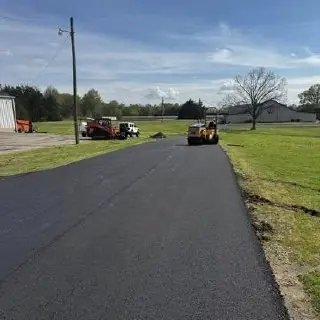 Newly paved driveway bordered by grass